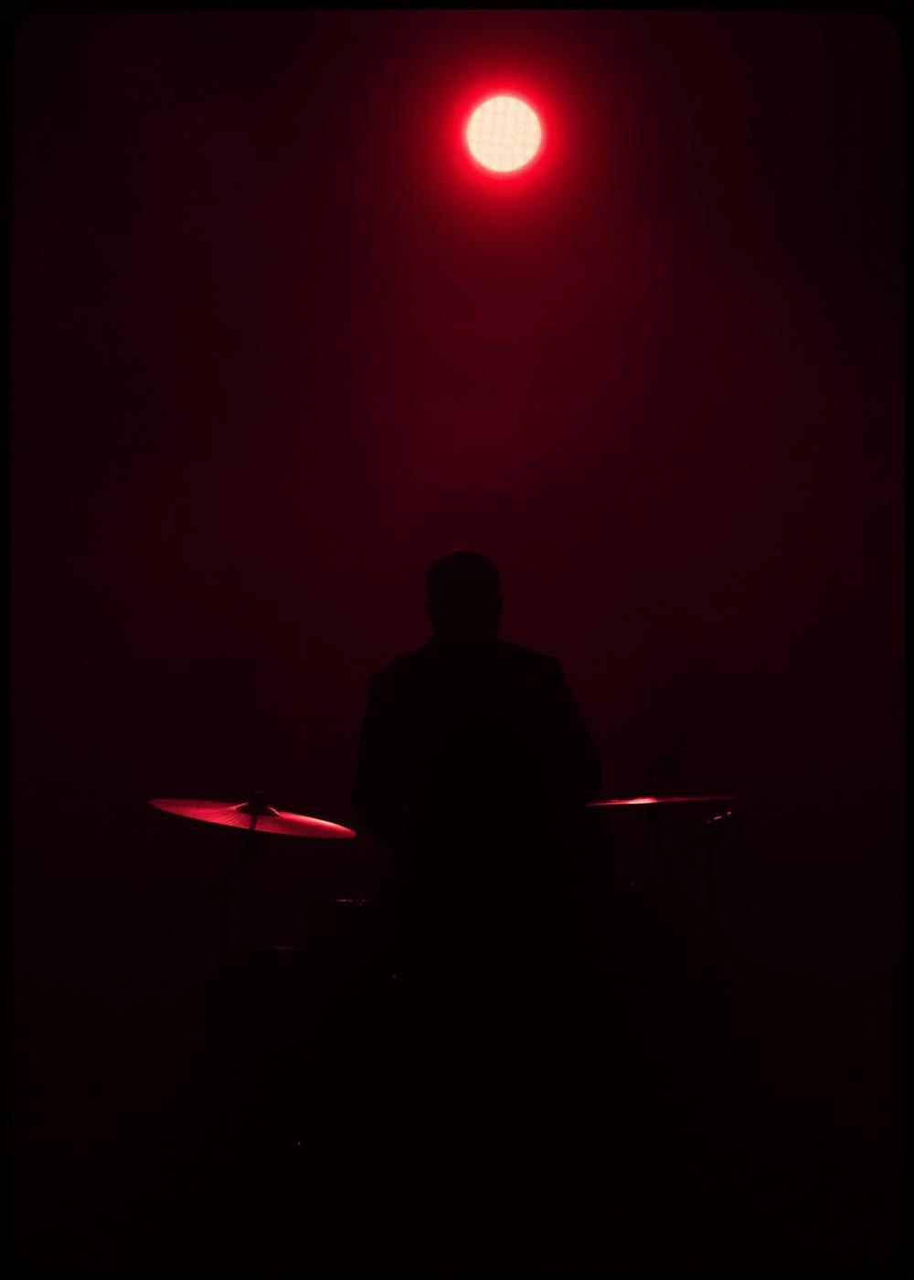 Drummer silhouette under red spot